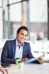 Pradeep Singh seated at a table holding a tablet